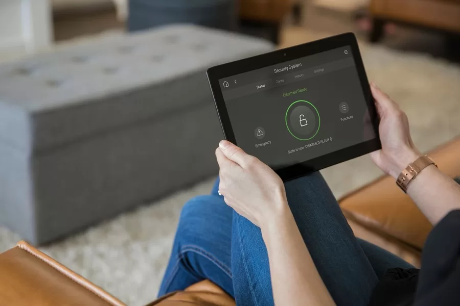 A person arming their home security system using the Control4 app.