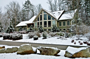 A large two-story home covered in snow in the winter.